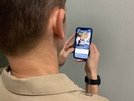 A Sailor reviews the recently updated Professional Military Knowledge-Eligibility Exam (PMK-EE) mobile application.