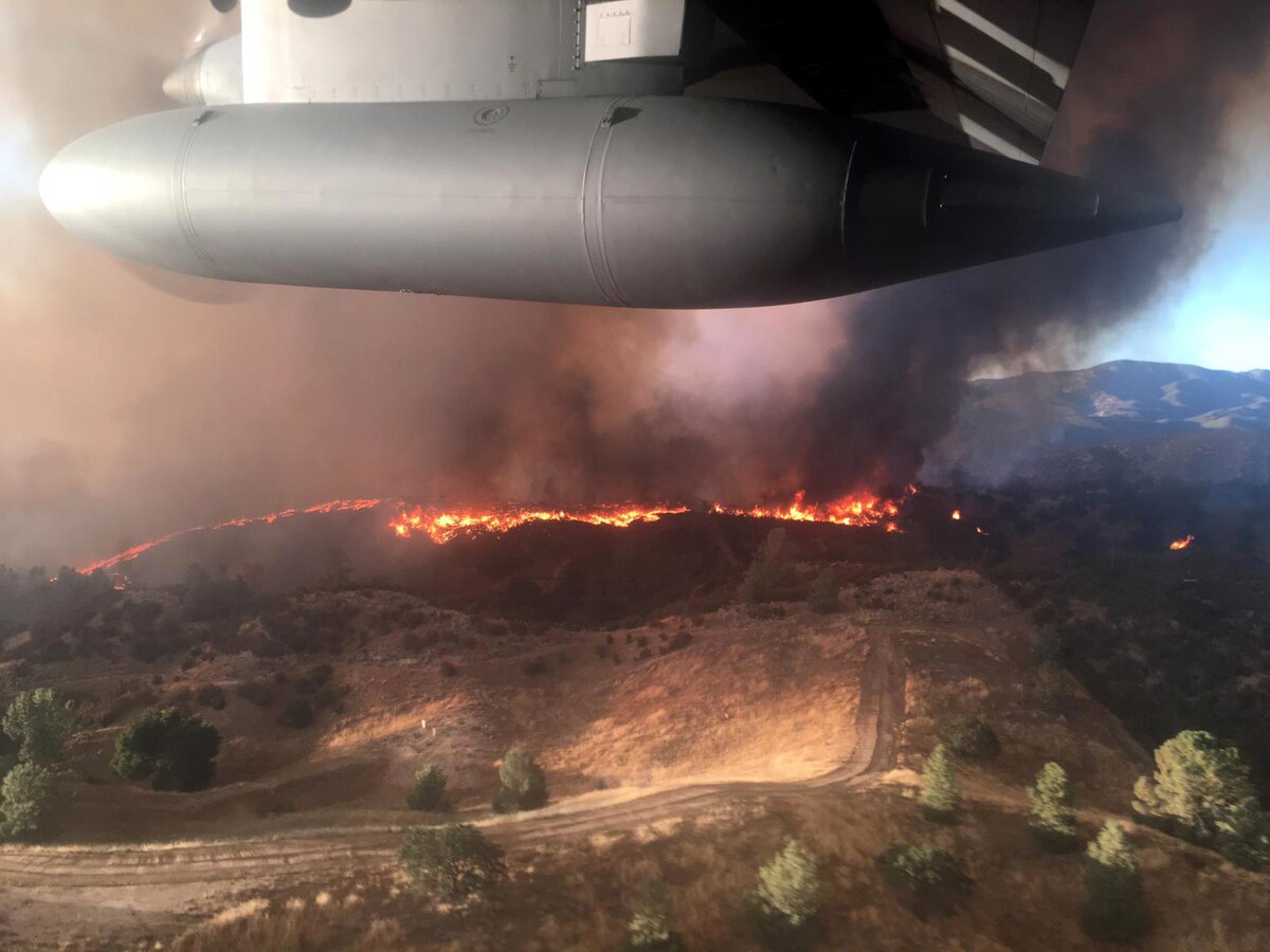 Large military aircraft flies over fires in California.