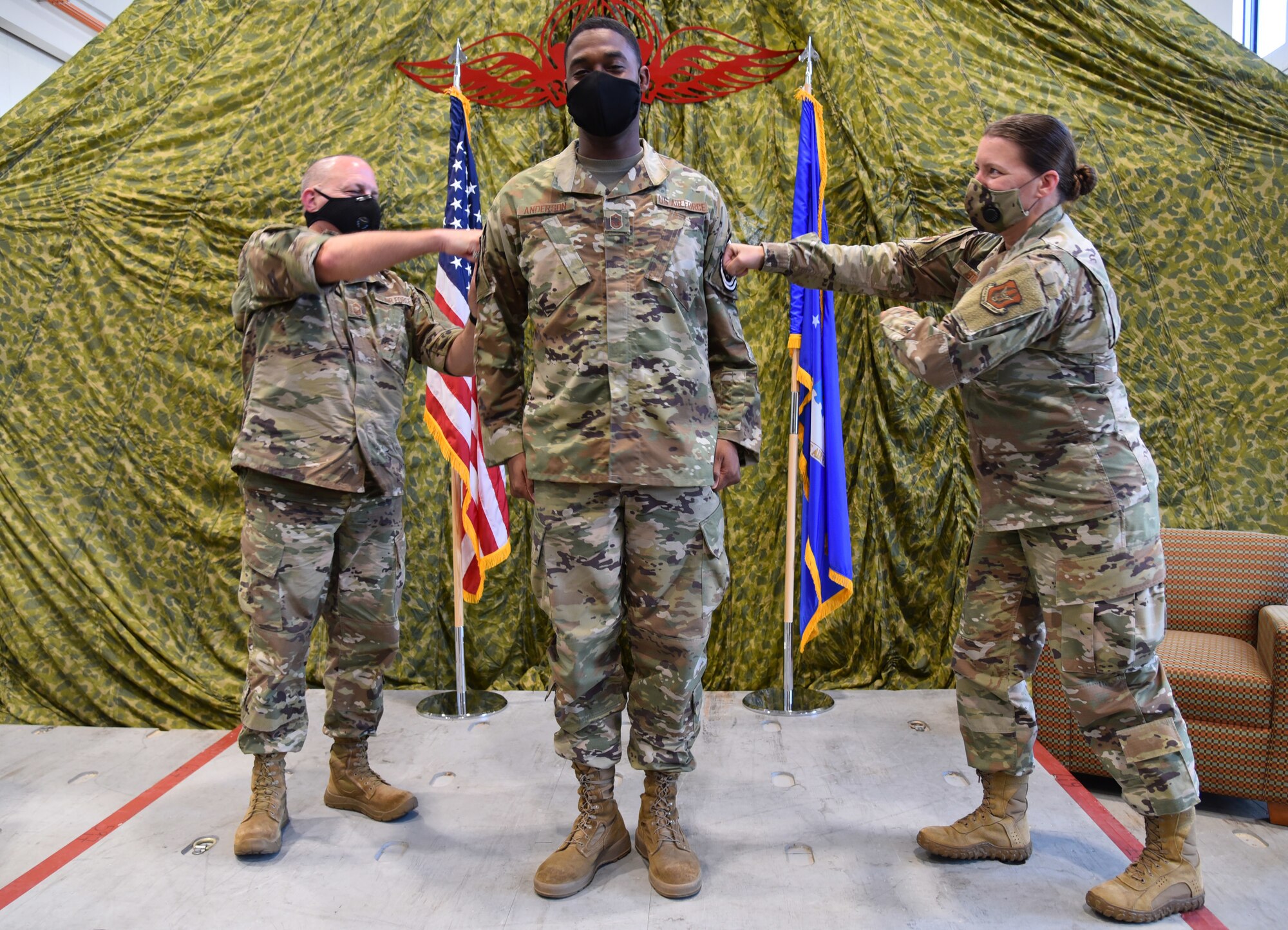 Chief Master Sgts. Monte Snyder, 403rd Maintenance Group maintenance operations superintendent (left) and Amanda Stift, 403rd Wing command chief, (right) "pin" the Chief Master Sgt. rank onto Senior Master Sgt. Larry Andersen, Superintendent, 403rd Wing Mission Support Group during his promotion ceremony August 8, 2020 at the 41st Aerial Port Squadron building, Keesler Air Force Base, Miss. (U.S. Air Force Photo by Tech. Sgt. Michael Farrar)