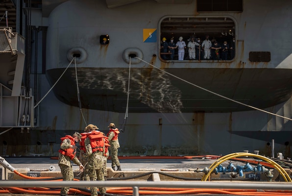 Sailors handle mooring lines as USS Dwight D. Eisenhower (CVN 69) returns to Naval Station Norfolk.