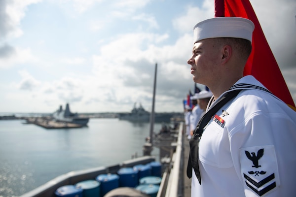 Aviation Structural Mechanic 2nd Class Brayten Tschoepe, from Knoxville, Tennessee, mans the rails as the Nimitz-class aircraft carrier USS Dwight D. Eisenhower (CVN 69) returns to Naval Station Norfolk.