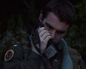U.S. Navy Lt. j.g. Evan Jones, Electronic Attack Squadron 131 electronic warfare officer, speaks on the radio during combat search and rescue training as part of Exercise Forest Thunder 20 at Draughon Range near Misawa Air Base, Japan, Aug. 3, 2020.  Jones learned how to execute the proper procedures during a rescue mission in a simulated real-world scenario. (U.S Air Force photo by Staff Sgt. Grace Nichols)