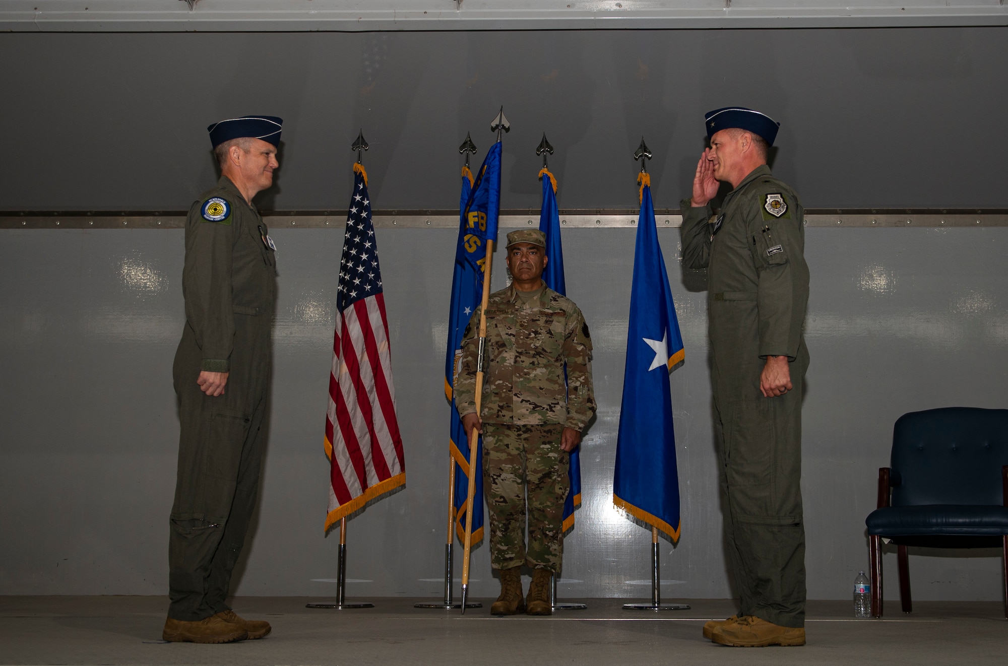 Brig. Gen. Michael Drowley salutes Maj. Gen. Charles Corcoran on stage during a ceremony.