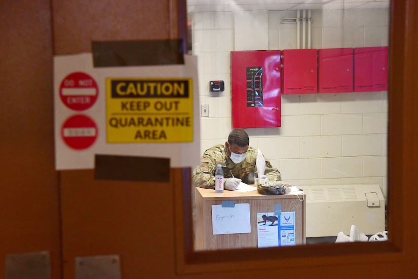 An airman works at a desk.