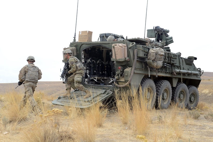 Military service members exit a combat vehicle.
