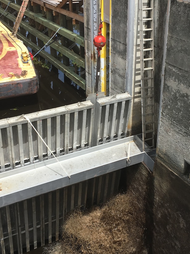 The crane operator starts to lift the slide plate, instantly relieving the hydraulic pressure and allowing water to start refilling the lock chamber.