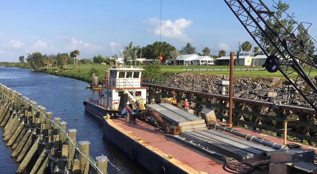 All components must be inspected months in advance, and are placed on the floating plant, which includes a barge-mounted crane and a tug to tow it to the work site. Panels for the needle system are stacked up on the deck so they are ready to be installed, and other equipment, such as large pumps are on board as well.