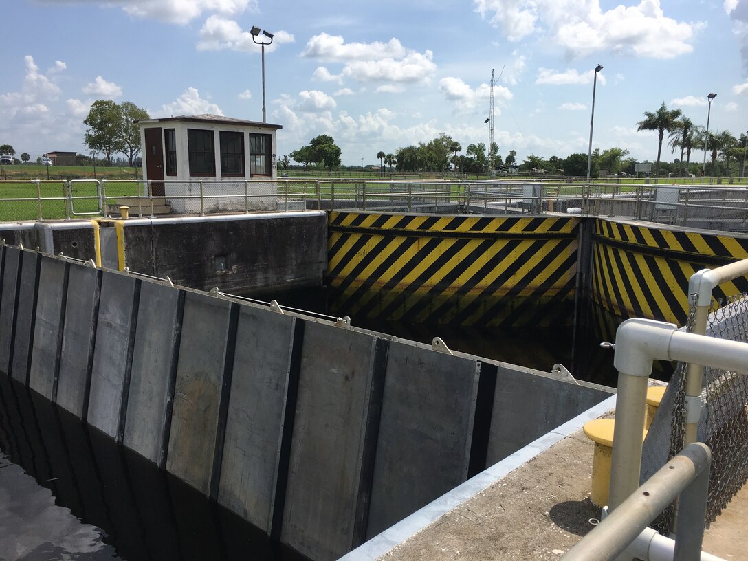 Seen from the upstream side, the needles have been placed in slots to form a temporary “cofferdam” adjacent to the yellow-and-black pie-shaped lock sector gates. The needle slots are located in the bottom of the lock chamber, about 30 feet on either side of the each set of gates. This makes it possible to dewater just one set of gates at a time, or to dewater the entire lock chamber at once.