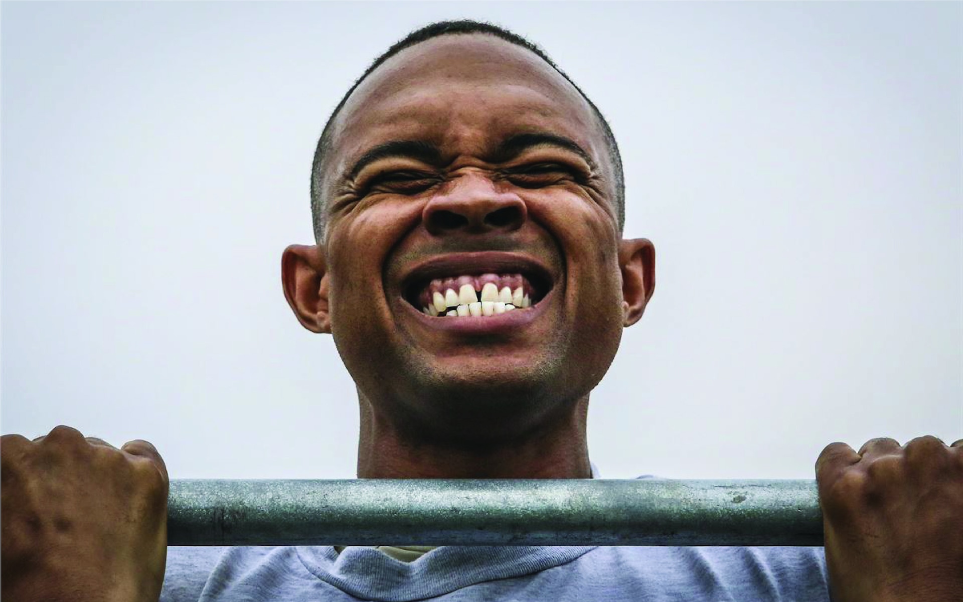 Close up on face of man doing pull-up