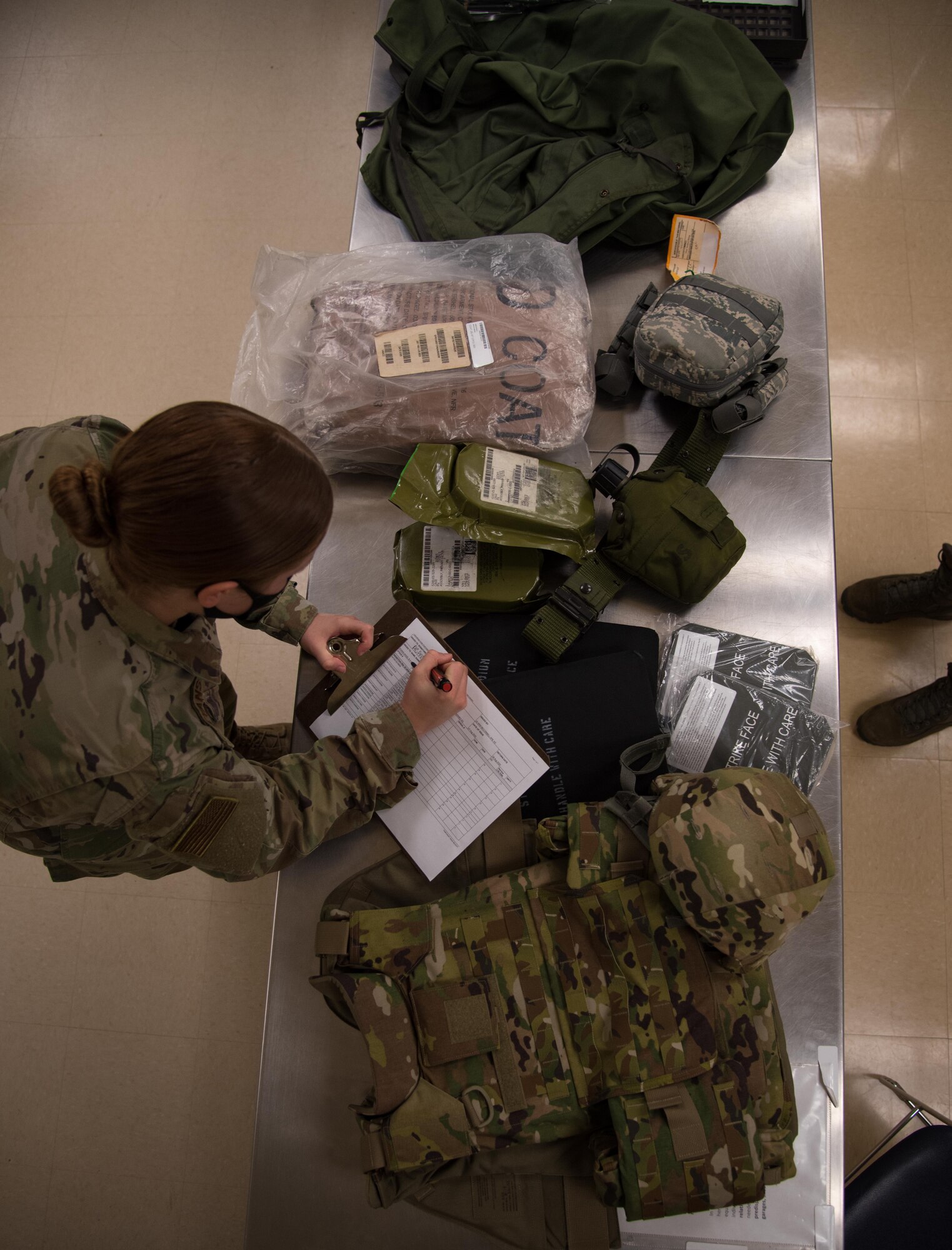 Airman 1st Class Angel Evans, 22nd Logistics Readiness Squadron individual protective equipment apprentice, issues mobility equipment Aug. 7, 2020, at McConnell Air Force Base, Kansas. Airmen tasked to deploy during the COVID-19 pandemic have increased protective measures during out processing in addition to the standard collection of their equipment. (U.S. Air Force photo by Senior Airman Michaela Slanchik)