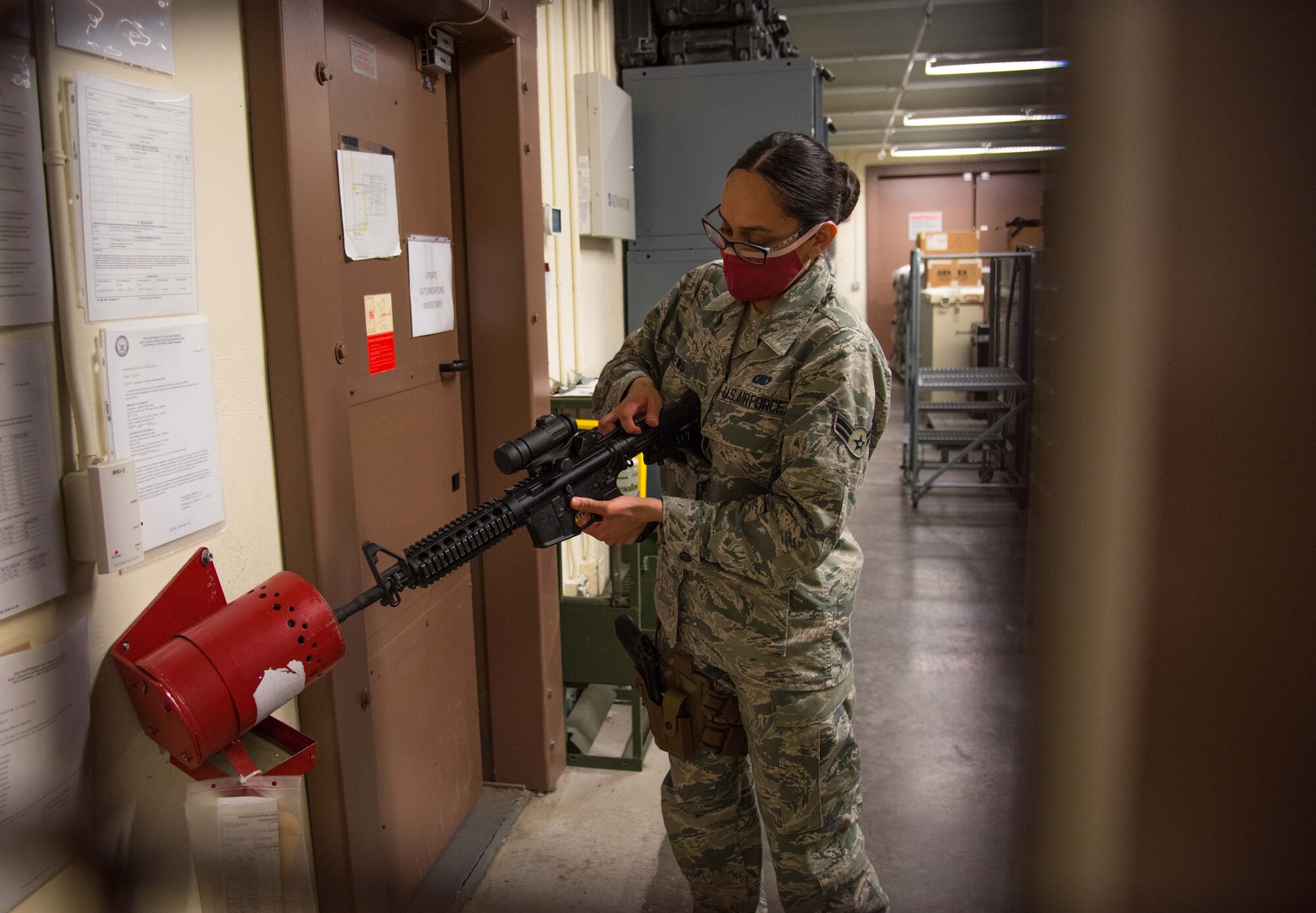 Airman 1st Class Maria Andrews, 22nd Logistics Readiness Squadron individual protective equipment apprentice, clears an M-4 prior to issue Aug. 7, 2020, at McConnell Air Force Base, Kansas. After an official deployment tasking is assigned, Airmen begin the process of collecting all mandatory equipment dependent on the deployment location. (U.S. Air Force photo by Senior Airman Michaela Slanchik)