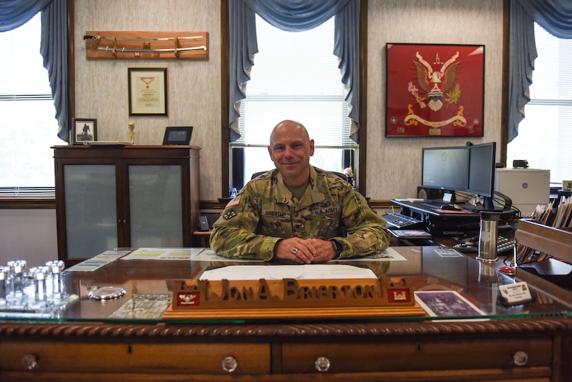 Photo of a colonel sitting at his desk.
