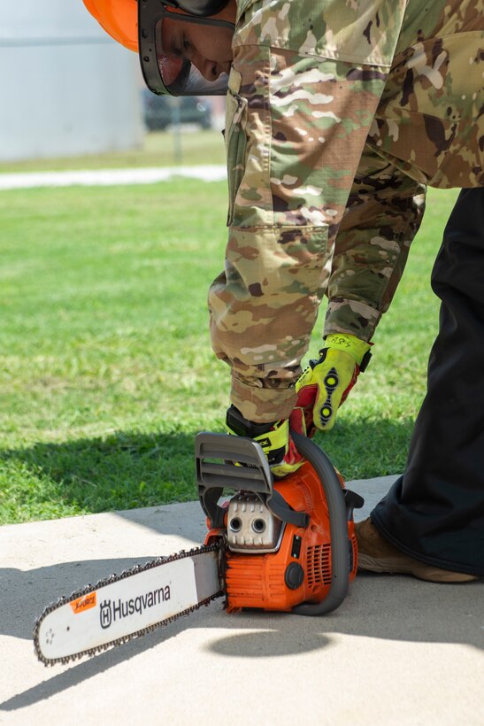A Soldier turns on a chainsaw.