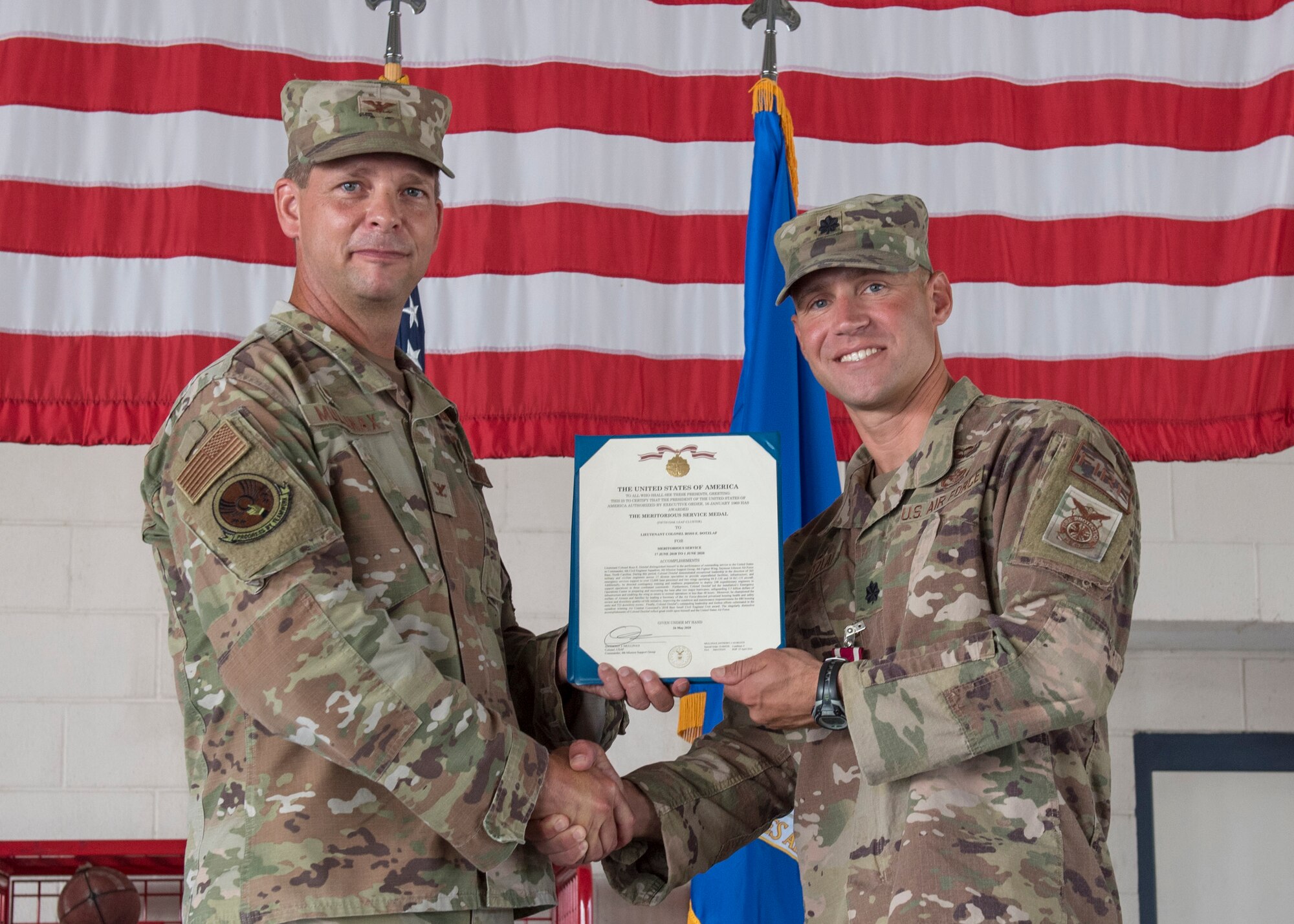 Col. Anthony Mullinax, 4th Mission Support Group commander (left), presents Lt. Col. Ross Dotzlaf, 4th Civil Engineer Squadron commander (right), with the Meritorious Service Medal during the 4th CES change of command ceremony at Seymour Johnson Air Force Base, North Carolina, August 10, 2020.