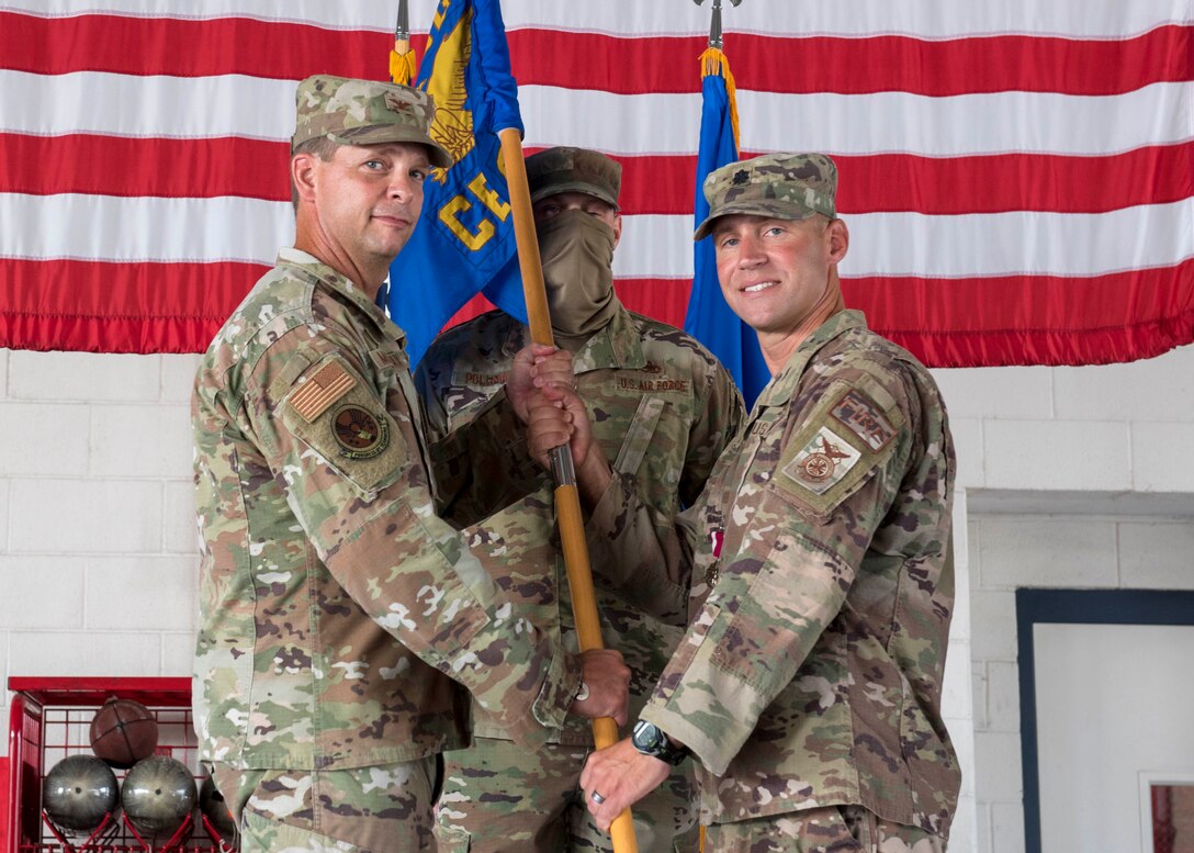Lt. Col. Ross Dotzlaf, 4th Civil Engineer Squadron commander (right), passes the guidon flag to Col. Anthony Mullinax, 4th Mission Support Group commander (left), during a change of command ceremony at Seymour Johnson Air Force Base, North Carolina, August 10, 2020.