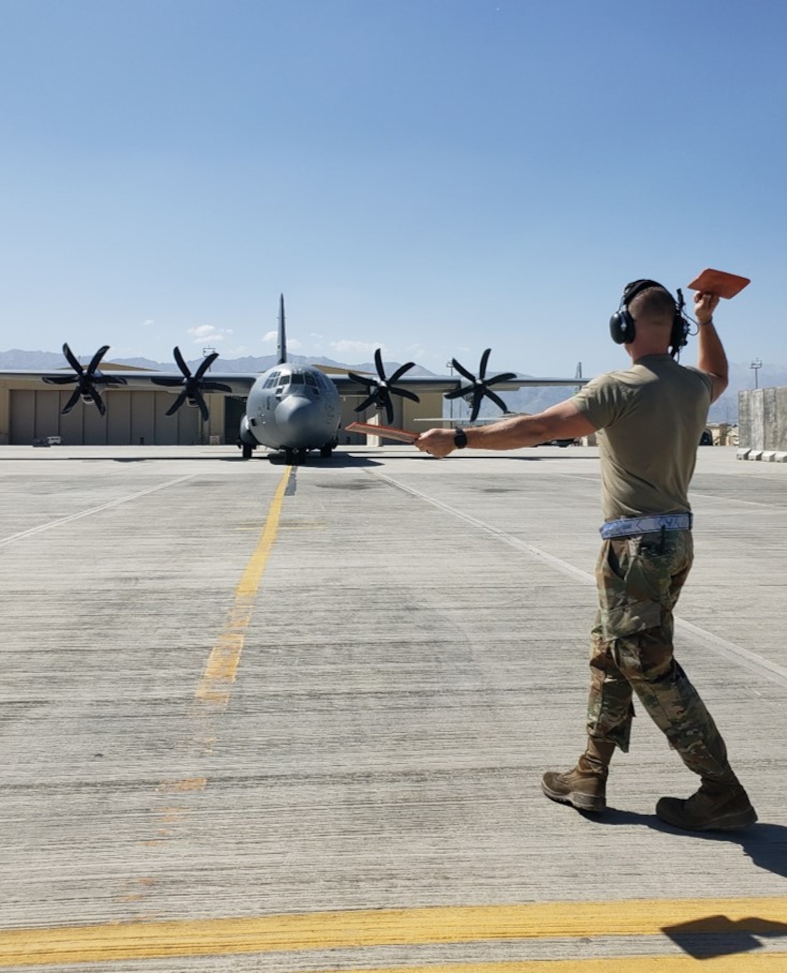 A maintainer marshals in a plane