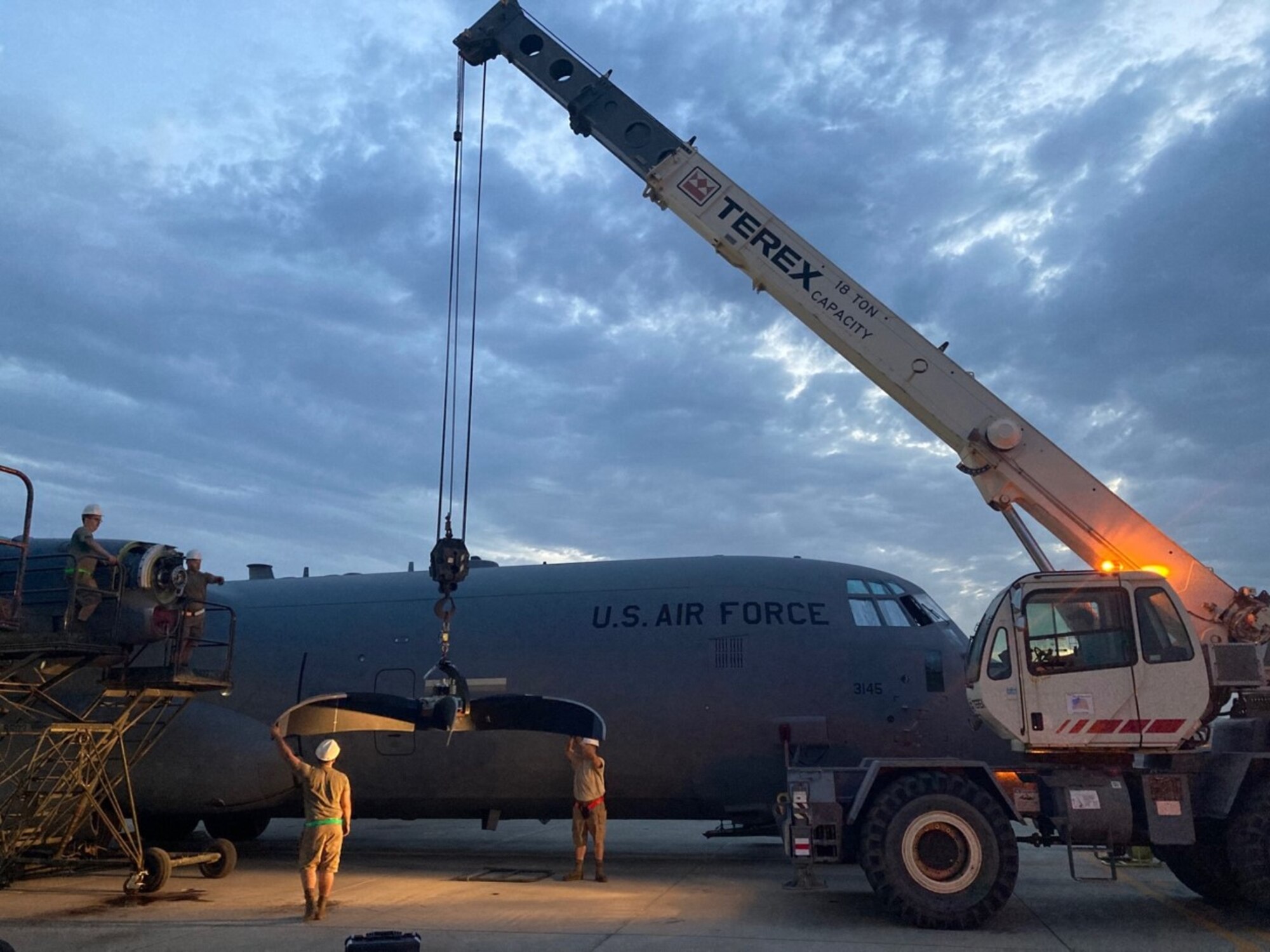 Maintainers prepare to put a new propeller on a plane