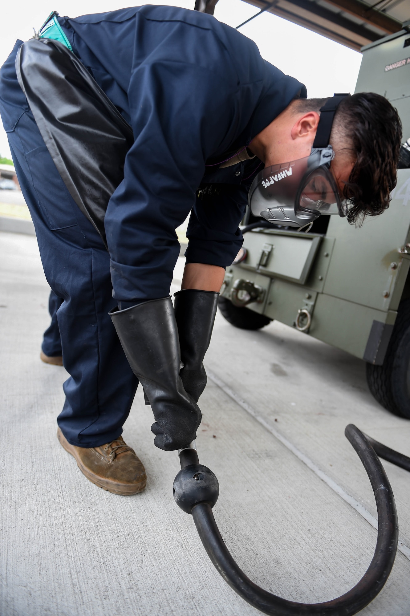 Senior Airman Patrick Christoffersen, 62nd Maintenance Squadron aerospace ground equipment (AGE) journeyman, adjusts a fuel hose during the defueling of a flight line generator unit in the AGE shop at Joint Base Lewis-McChord, Wash., Aug. 3, 2020. Before being loaded onto a C-17 Globemaster III, fuel is drained from cargo to prevent any leakage on the aircraft. (U.S. Air Force photo by Airman 1st Class Mikayla Heineck)