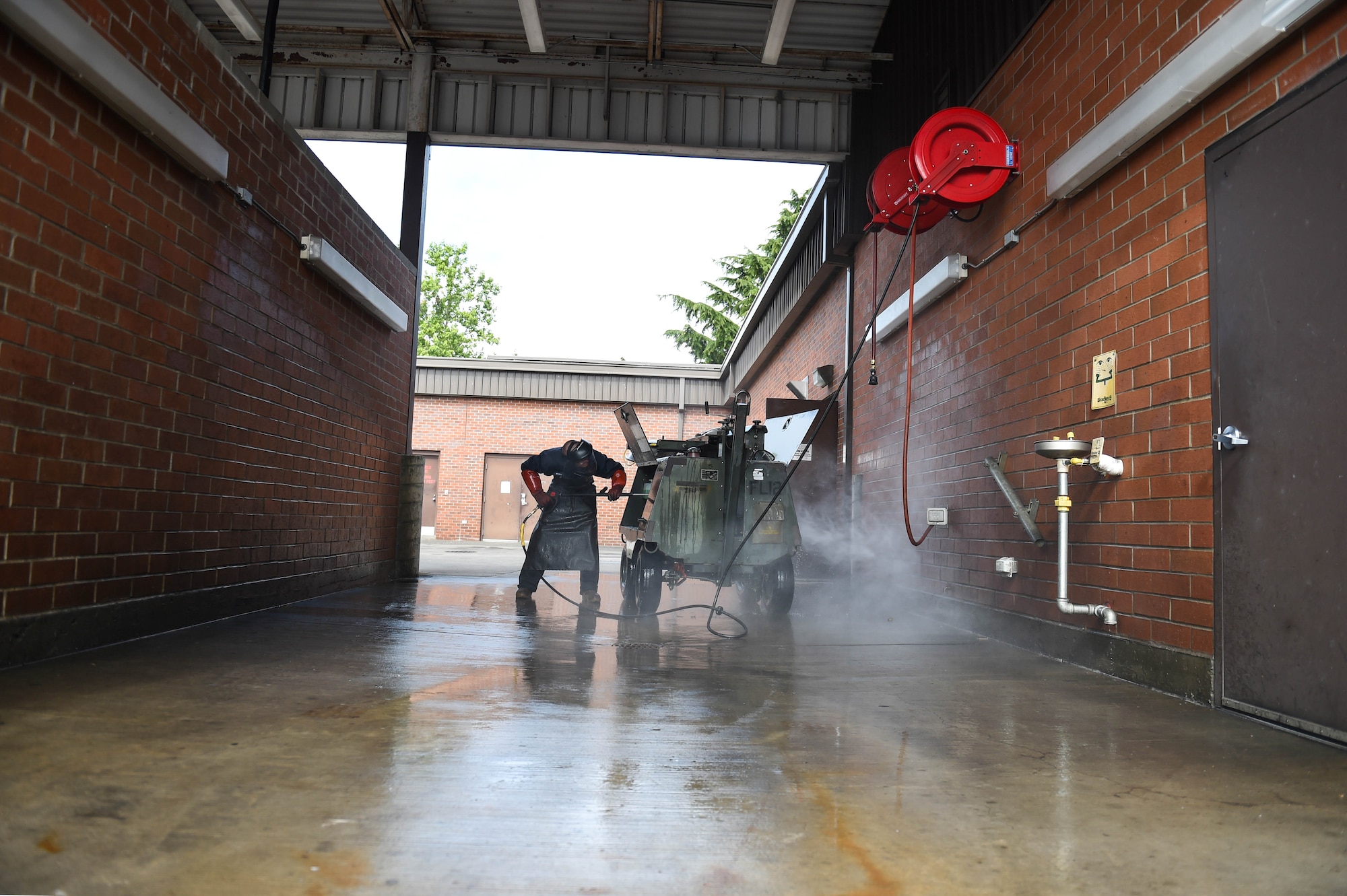 Senior Airman Michael Holder, 62nd Maintenance Squadron aerospace ground equipment (AGE) journeyman, pressure washes a floodlight unit in preparation for on-load onto an aircraft on Joint Base Lewis-McChord, Wash., Aug. 3, 2020. Pressure washing flight line equipment that requires fuel to be operated is standard to prevent any excess oils, leakage or fuels from getting onto the aircraft. (U.S. Air Force photo by Airman 1st Class Mikayla Heineck)