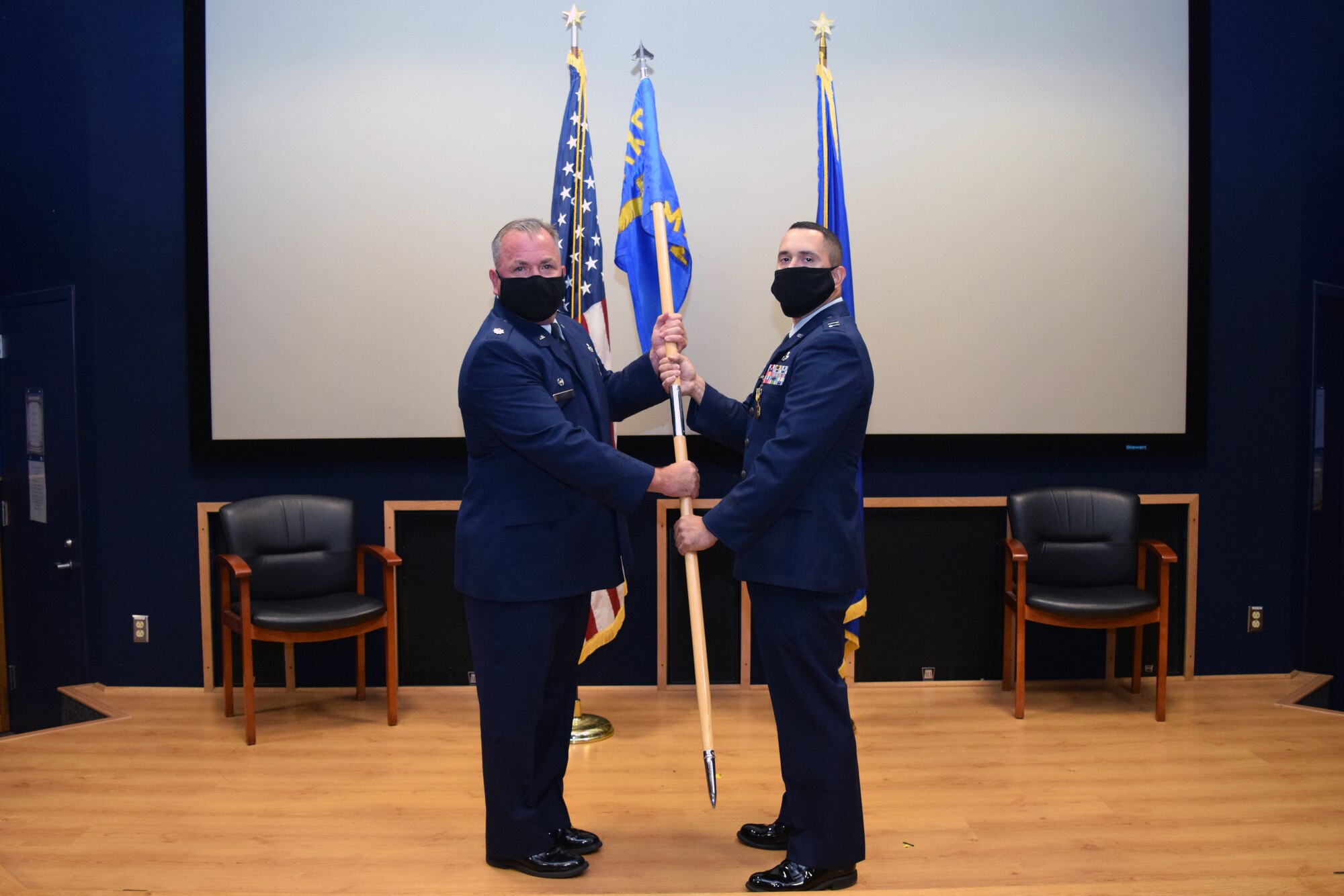 Lt. Col. Stuart Martin, 433rd Maintenance Group commander, presents the guidon to Capt. Nicholas Velazquez, 433rd Maintenance Squadron commander, at an assumption of command ceremony Aug. 8, 2020 at Joint Base San Antonio-Lackland, Texas.