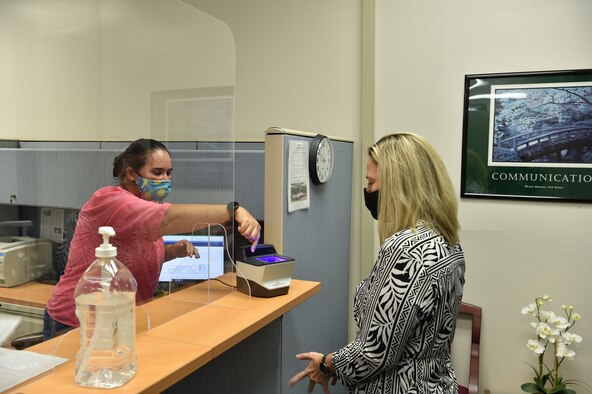 Leslie Bryant, Civilian Personnel Office staffing chief, demonstrates how to give fingerprints to Jayme Alexander, Airmen and Family Readiness Center casualty assistance representative selectee, at Joint Base Pearl Harbor-Hickam, Hawaii, August 7, 2020. The CPO is responsible for hiring, managing, and assisting civilian employees for the Air Force. (U.S. Air Force Photo by 2nd Lt. Benjamin Aronson)