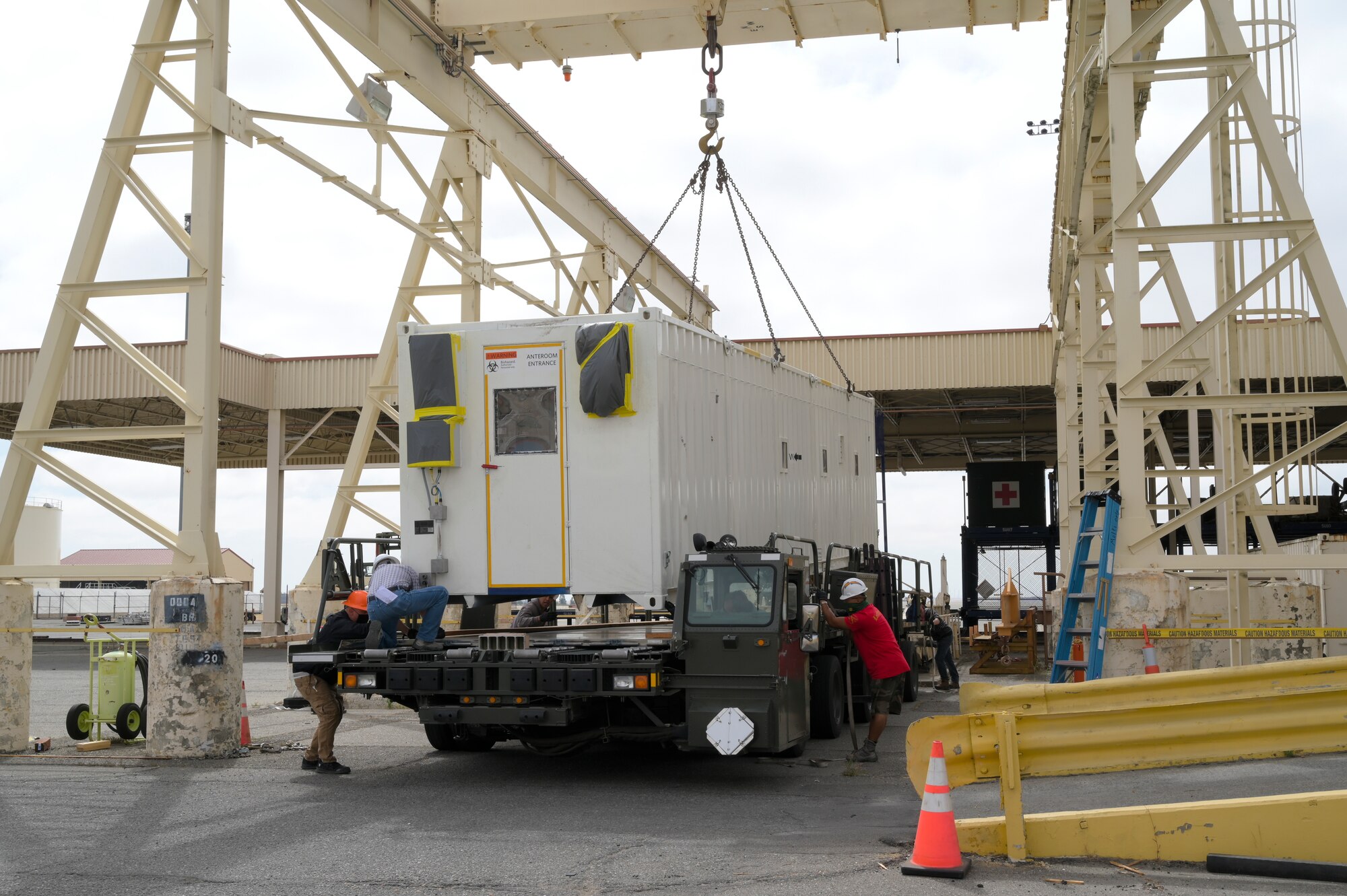 U.S. Airmen assigned to the 60th Aerial Port Squadron use a 35-ton bridge crane to load a Negatively Pressurized Conex onto a Tunner 60k loader.