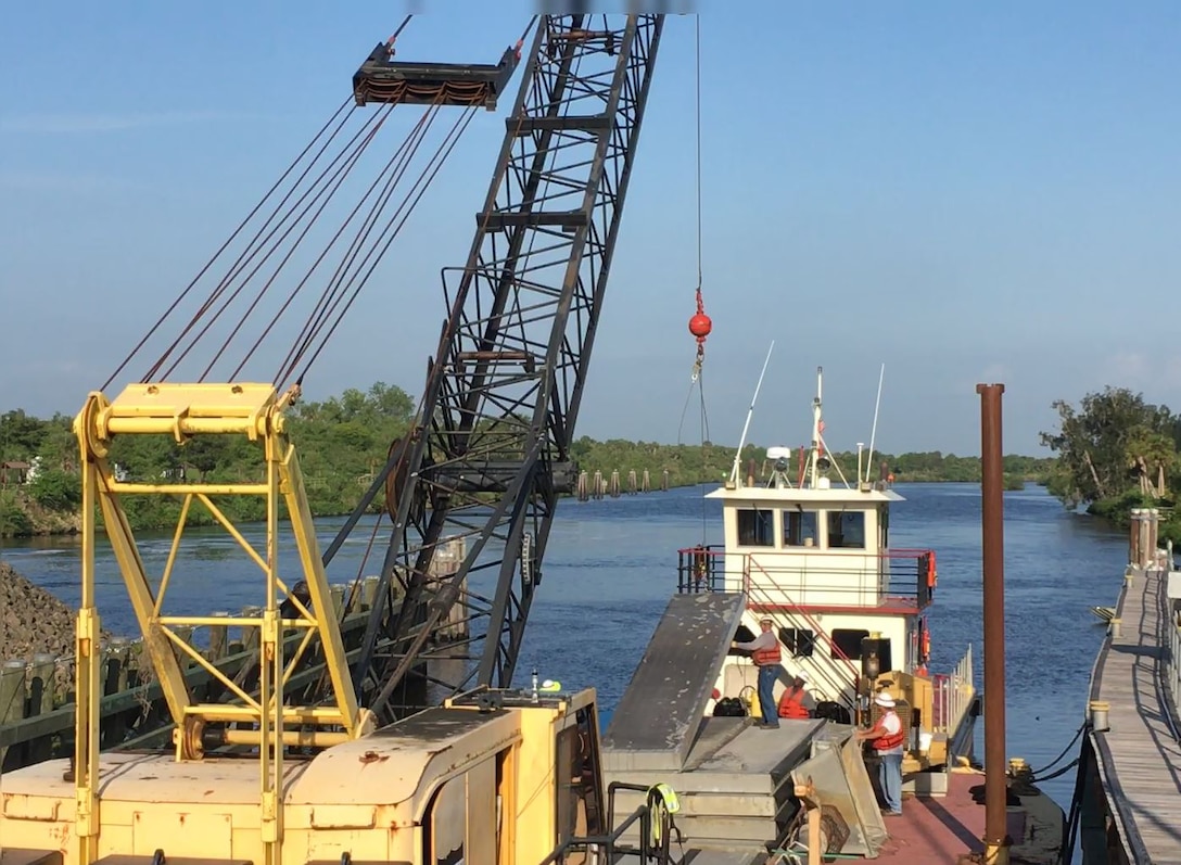 The crane operator lifts the needles that have been staged on the barge.