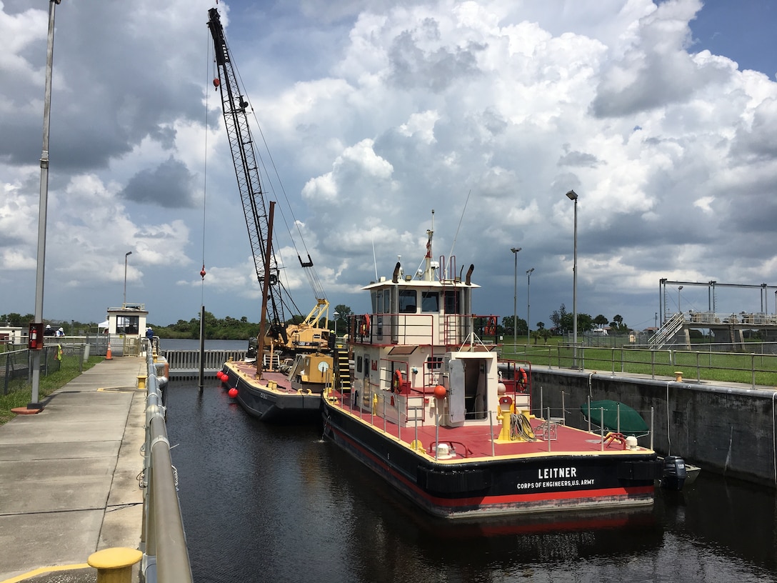 The crane operator picks up and rotates the needles toward the needle slots, where they are inserted close enough together that they will seal. Divers are again in the water to help to assure that the needles are placed properly.