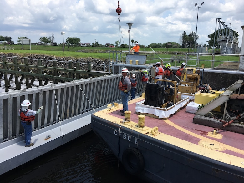 The team secures the needles to the girder. The natural hydraulic pressure of the river presses the needles toward the girder, and also holds a curtain that is installed on the upstream side of the needles to provide an additional seal.