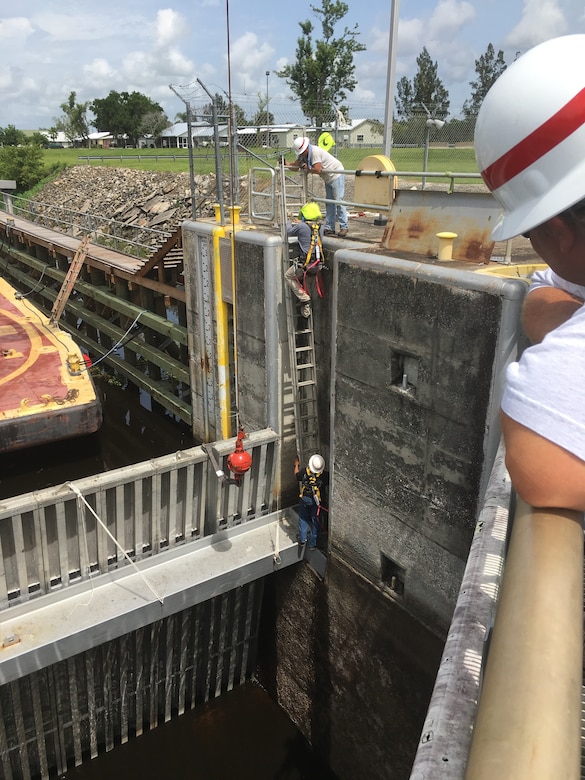 Corps team members exit the lock chamber as everyone else watches eagerly in anticipation of the symbolic final moment of the dewatering process.