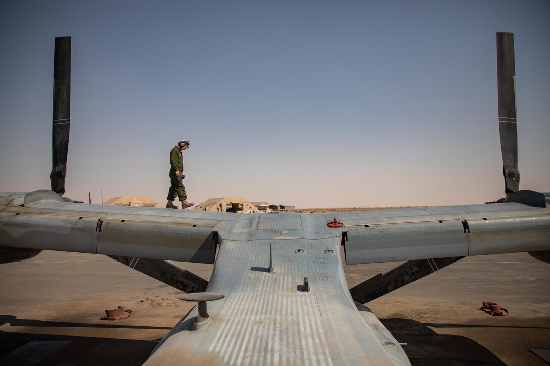 A U.S. Navy crew chief with Marine Medium Tiltrotor Squadron 166 (Reinforced,) assigned to the Special Purpose Marine Air-Ground Task Force - Crisis Response - Central Command 20.2, conducts a routine inspection for a MV-22B Osprey