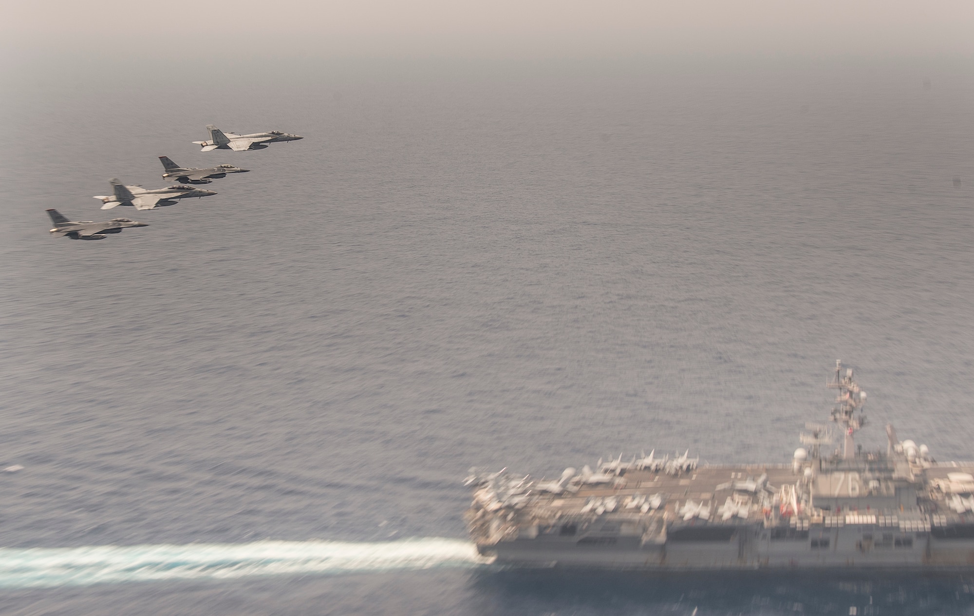 Two F-16 Fighting Falcons and two F/A-18E Super Hornets soar over the U.S.S.  Ronald Reagan off the Northern Coast of Japan, Aug. 5, 2020.The U.S. Navy and Air Force conducted joint intergrated training off the coast of Northern Japan. Units and personnel assigned to the Ronald Reagan Carrier Strike Group, Navy Electronic Attack Squadron (VAQ) 131, and the Air Force 35th FIghter Wing began coordinated operations Aug. 1. (U.S. Air Force photo by Staff Sgt. Brittany A. Chase)