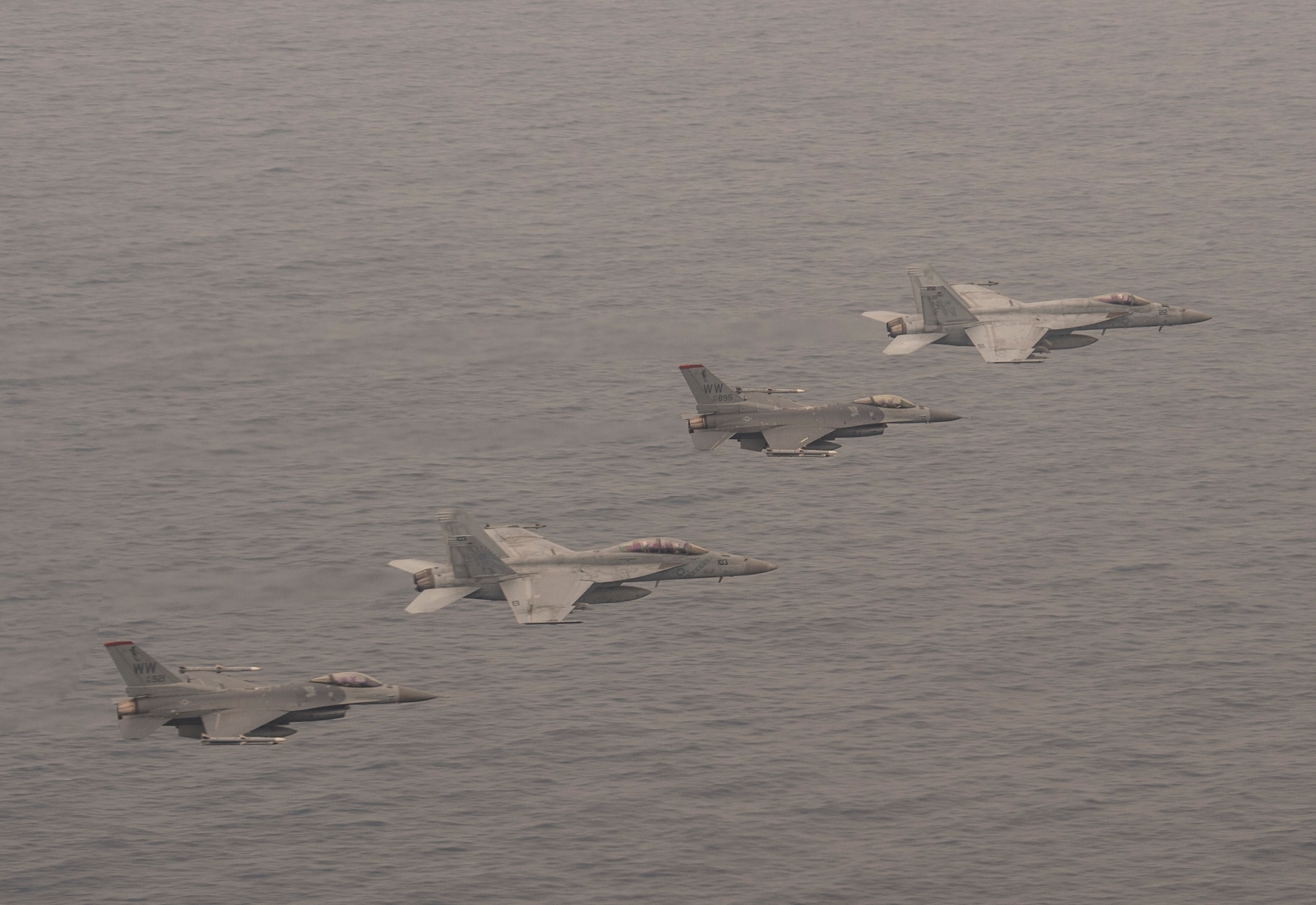 Two F-16 Fighting Falcons and two F/A-18E Super Hornets soar over the Northern Coast of Japan, Aug. 5, 2020.The U.S. Navy and Air Force conducted joint intergrated training off the coast of Northern Japan. Units and personnel assigned to the Ronald Reagan Carrier Strike Group, Navy Electronic Attack Squadron (VAQ) 131, and the Air Force 35th FIghter Wing began coordinated operations Aug. 1. (U.S. Air Force photo by Staff Sgt. Brittany A. Chase)