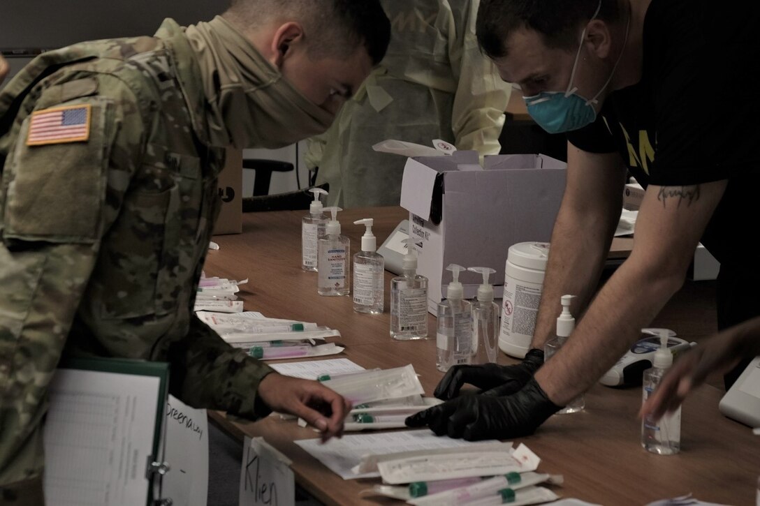 Medical Soldiers from the 7th Army Training Command, United States Army Garrison Bavaria, provide COVID 19 screening to U.S. Army Reserve Soldiers of the 7th Mission Support Command during in-processing for exercise Forward and Ready 20 at USAG Bavaria in Grafenwoehr, July 25, 2020.