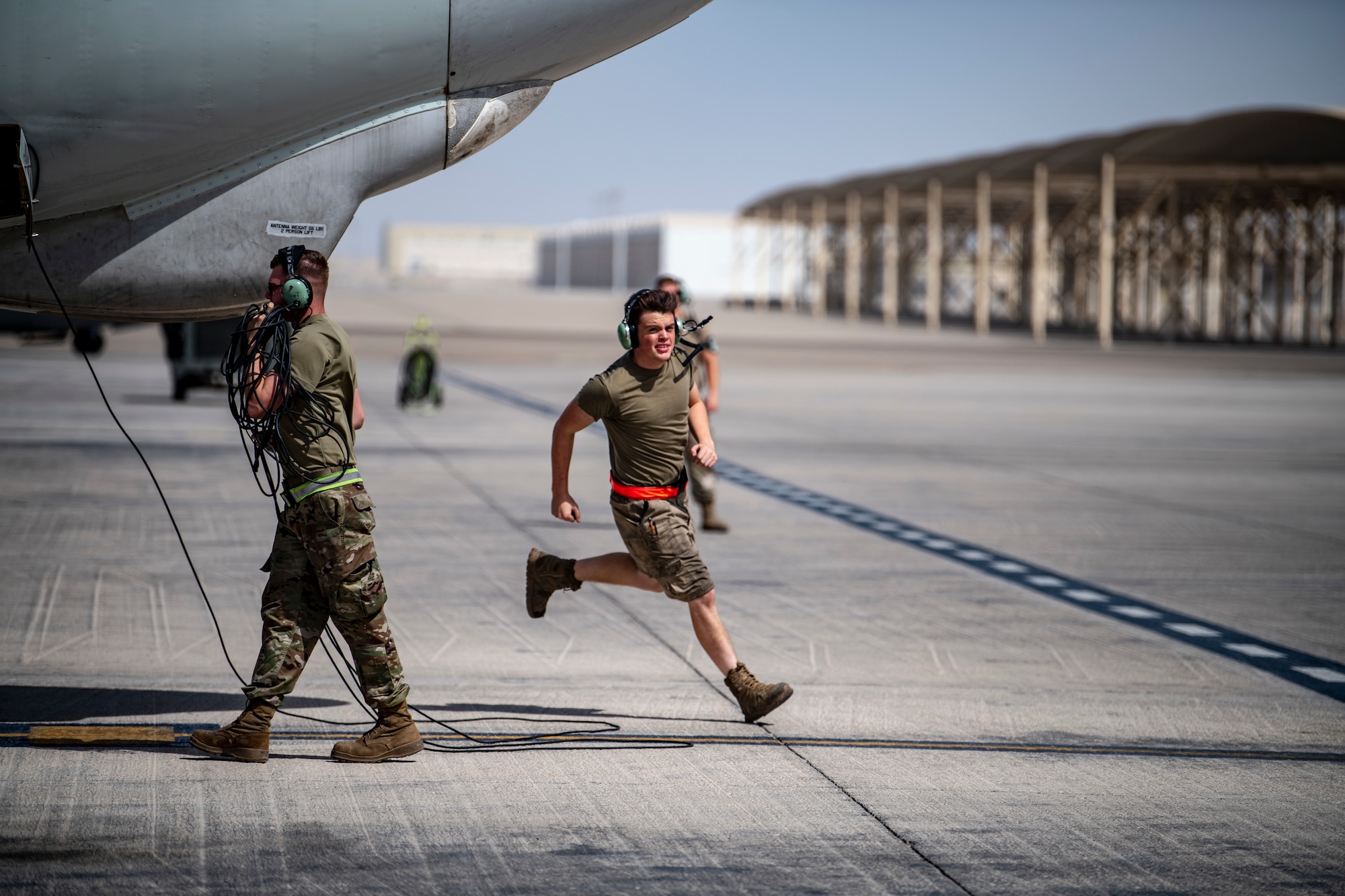 Senior Airman Jack Melon, 380th Expeditionary Aircraft Maintenance Squadron E-3 Sentry Aircraft Maintenance Unit, briskly moves away after unchocking tires of an E-3 Sentry for flight here July 28, 2020.