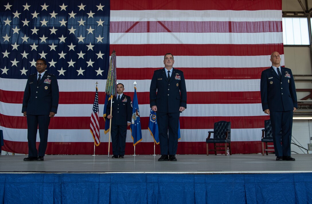 Four people standing at attention on a stage.