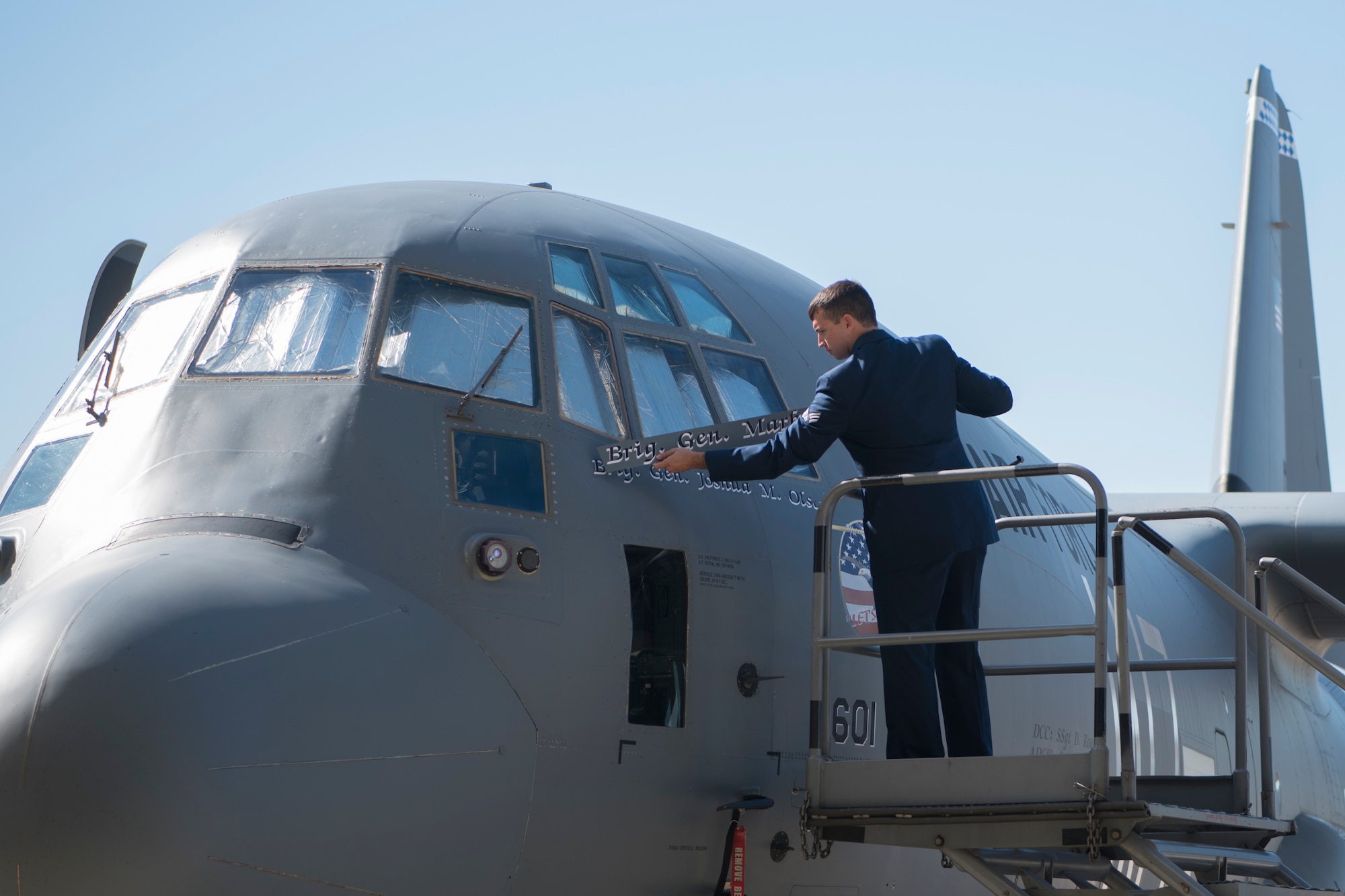 A man removing a name plate from an aircraft.