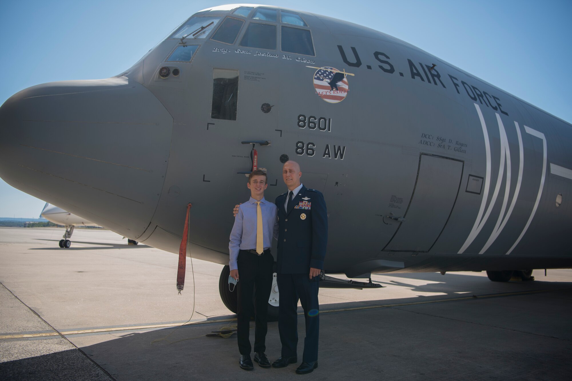 Two people standing in front of an aircraft.