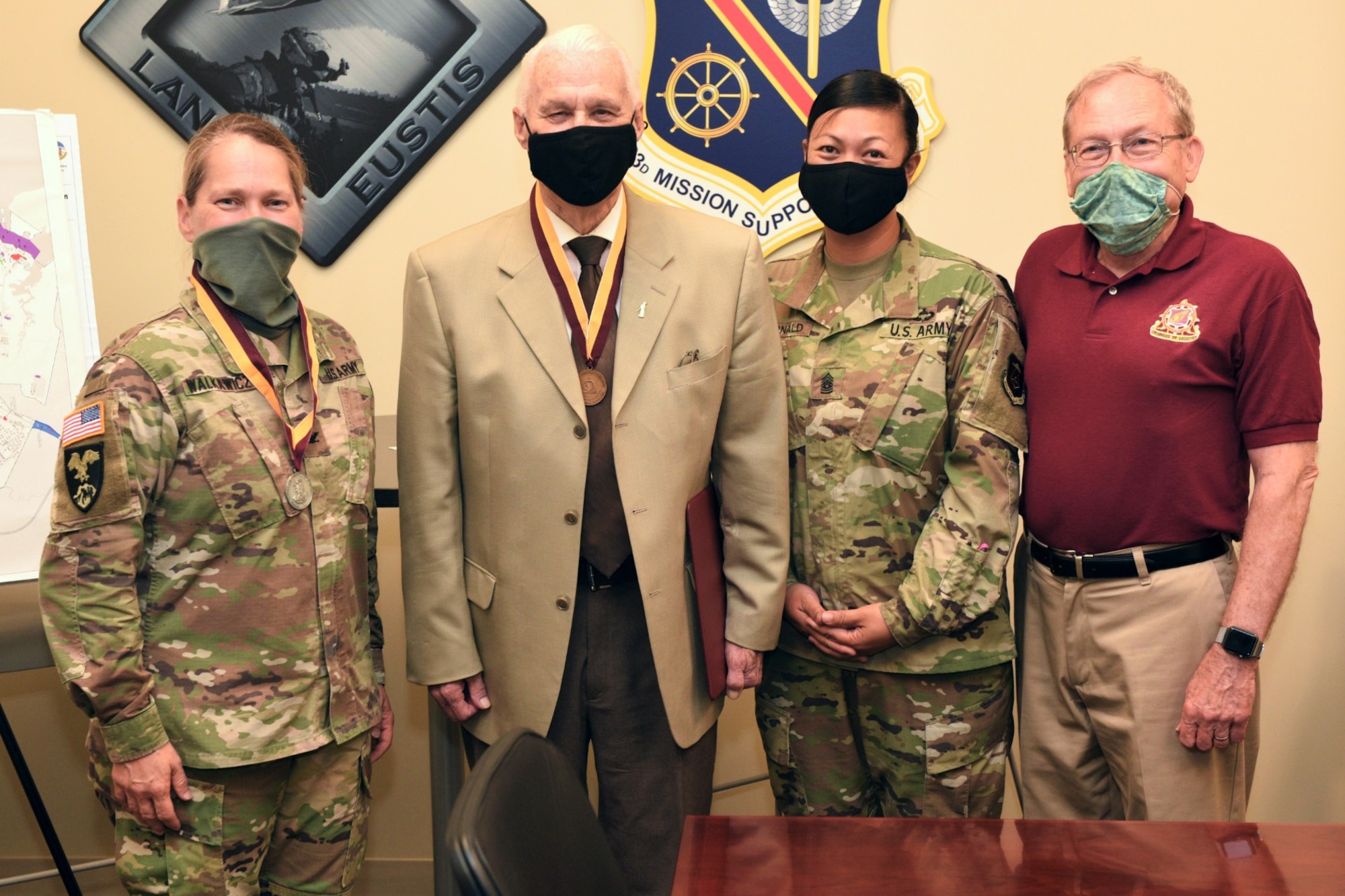 A group of four people pose for a photo.