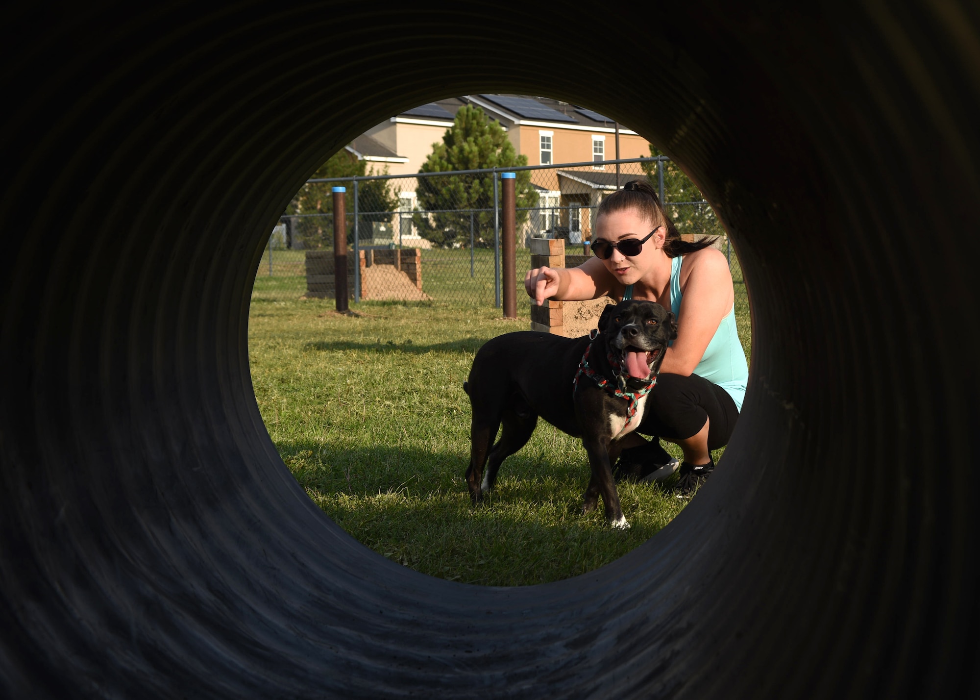 Tiffany Blevins, Air Force spouse, tells her dog, Little Man, to go into the tunnel at the newly transformed dog park on Buckley Air Force Base, Colo., Aug. 4, 2020. Spencer Fogg transformed the dog park to fulfill his community service project requirement to become an Eagle Scout. (U.S. Air Force photo by Airman 1st Class Haley N. Blevins)