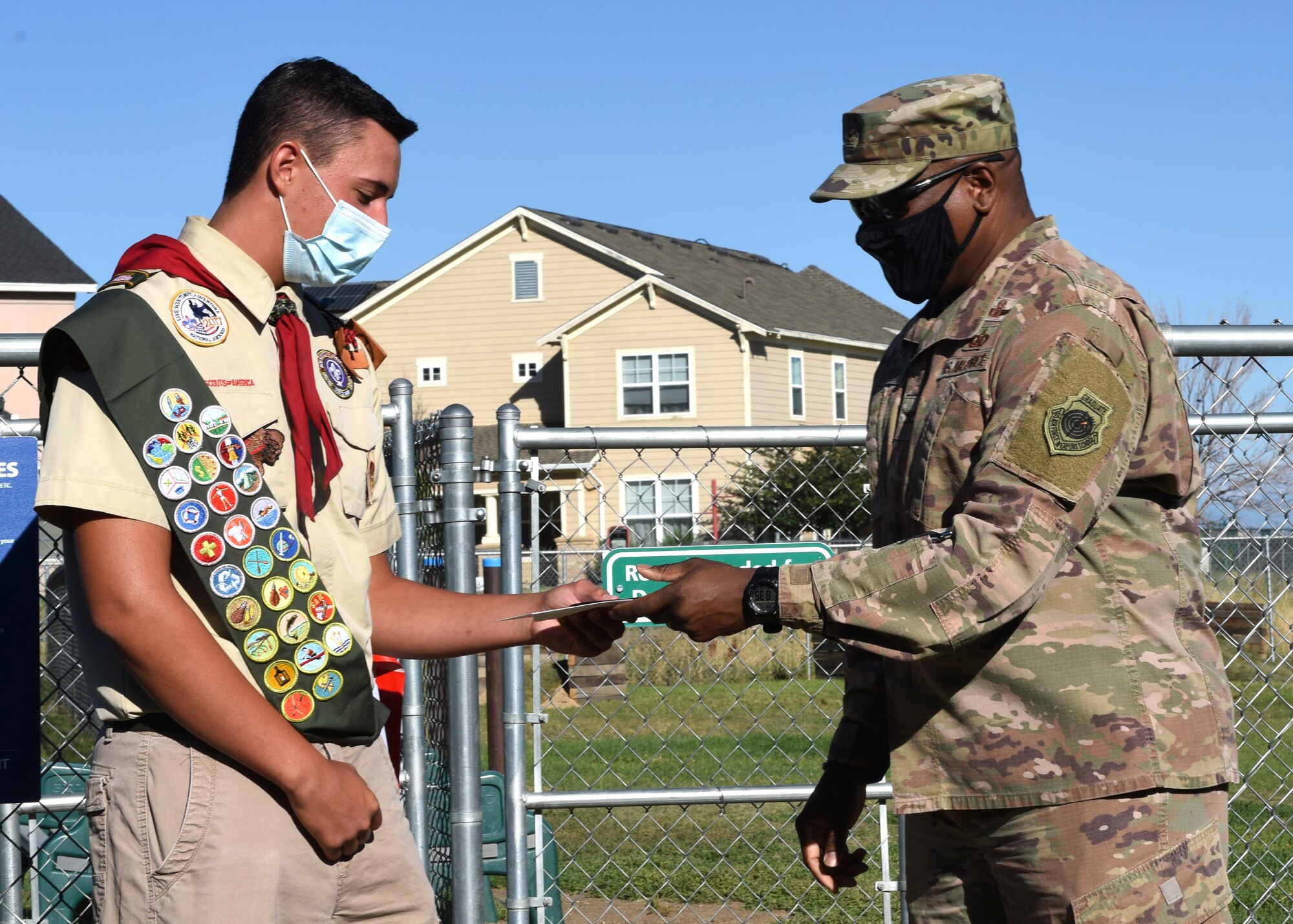 Col. Devin Pepper, Buckley Garrison commander, presents a memento to Spencer Fogg, Eagle Scout, for transforming the dog park on Buckley Air Force Base, Colo., Aug. 7, 2020. Fogg coordinated and completed the transformation of the dog park by installing ramps, hurdles, tunnels and poles to weave through at the dog park to fulfill his community service project requirement to become an Eagle Scout. (U.S. Air Force photo by Airman 1st Class Haley N. Blevins)