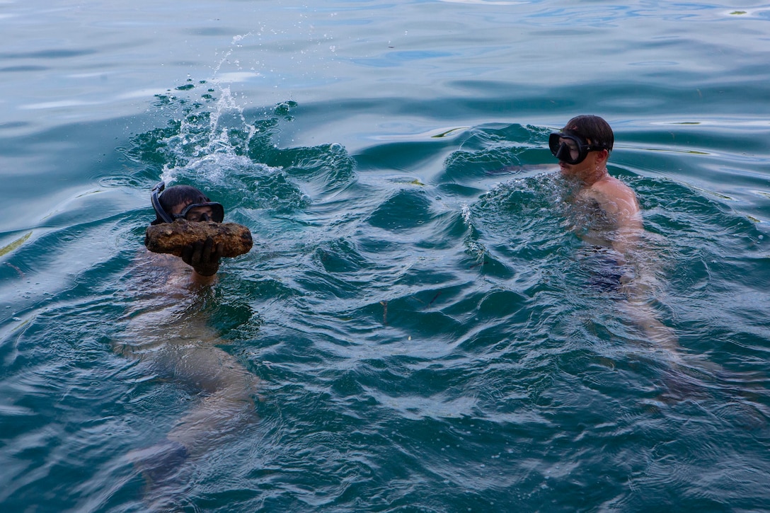 U.S. Marine relocate an unexploded ordnance item to a designated safe area in Peleliu, Republic of Palau, July 28.