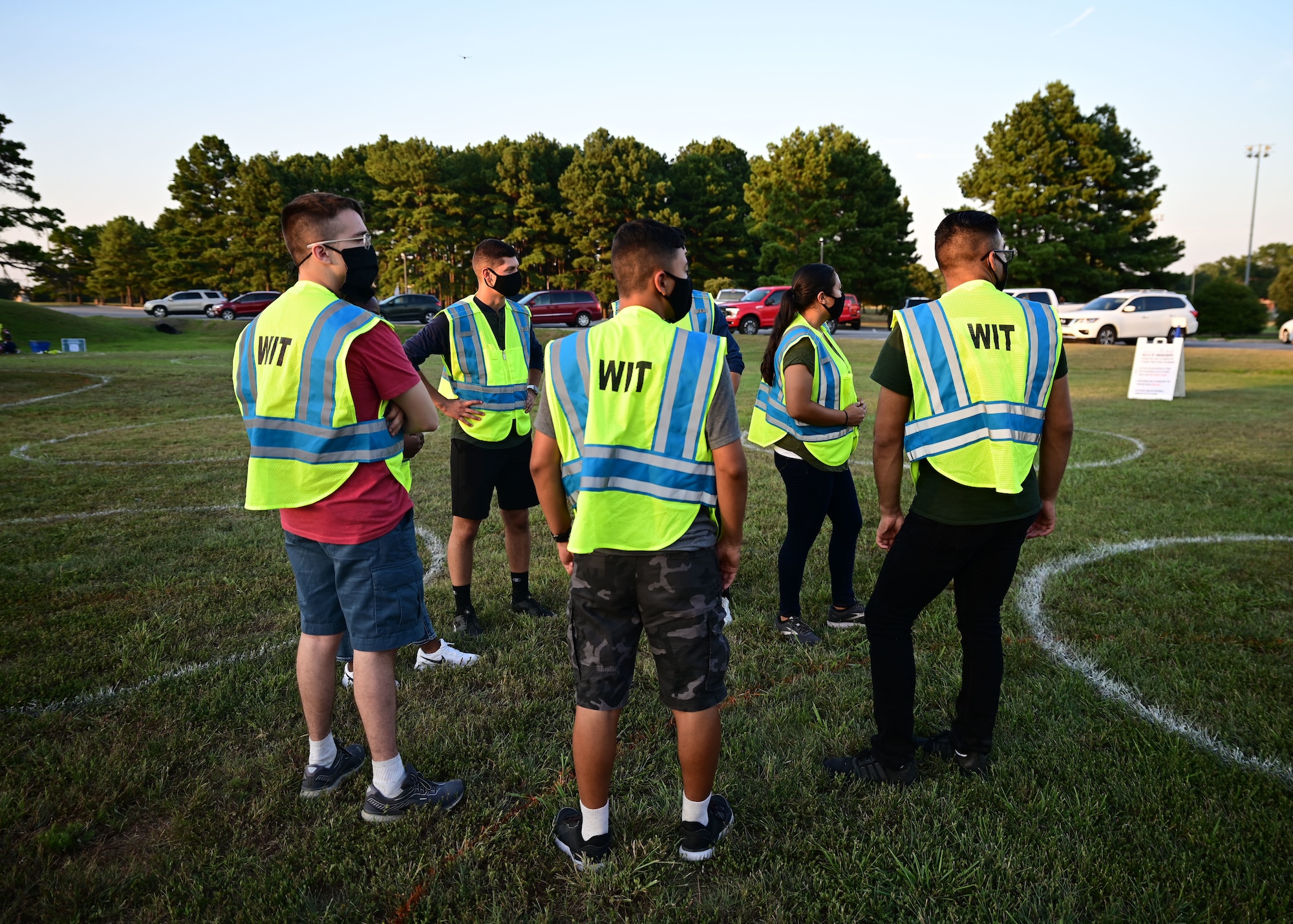 A group of people monitors a crowd to ensure social distancing
