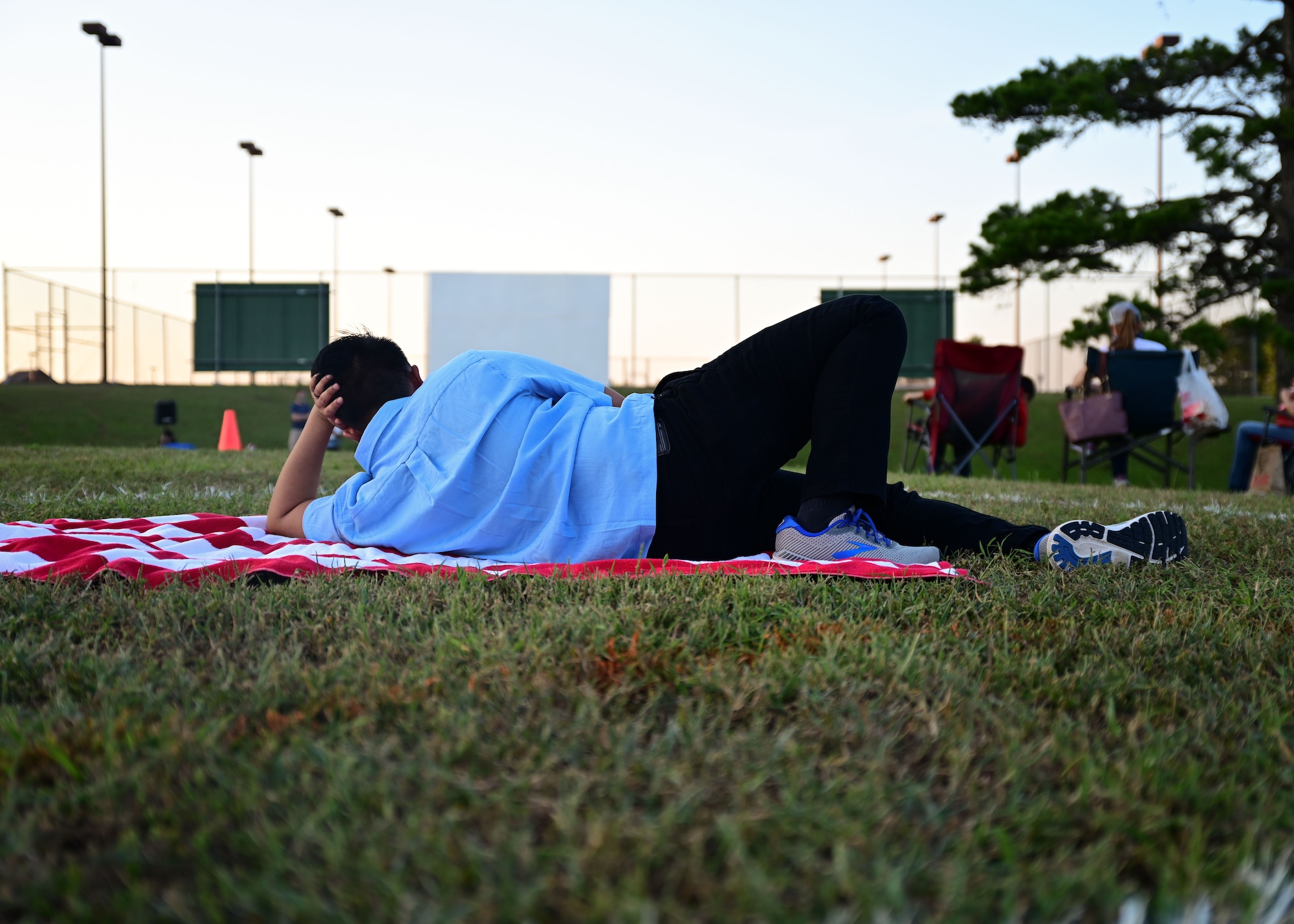 A man watches a movie in the base park