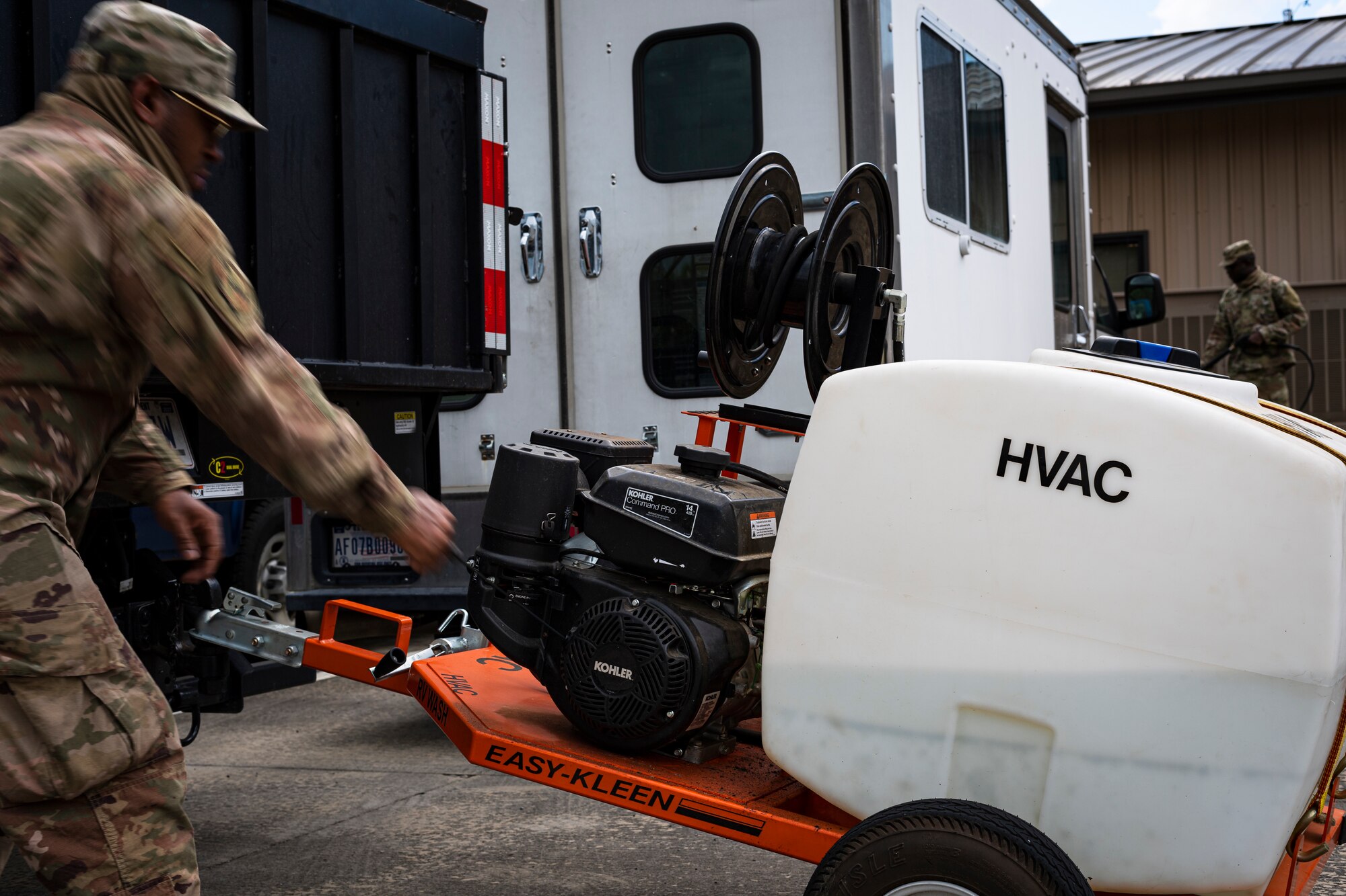 A photo of an Airman starting up a pressure washer