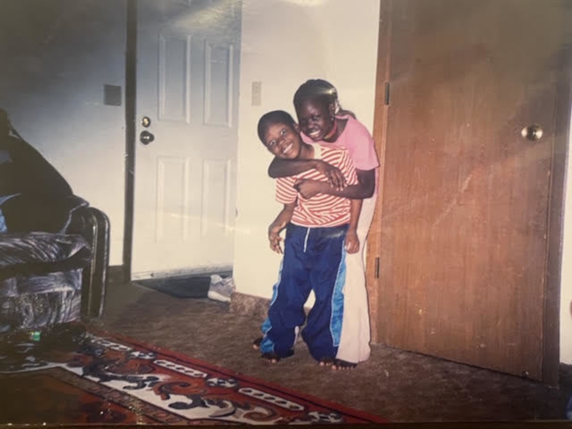 Airman 1st Class Nyarauch Chuol, passenger operations representative with the 32nd Aerial Port Squadron, poses for a photo with her brother Lul Chuol in Rosemount, Minnesota, 2003.