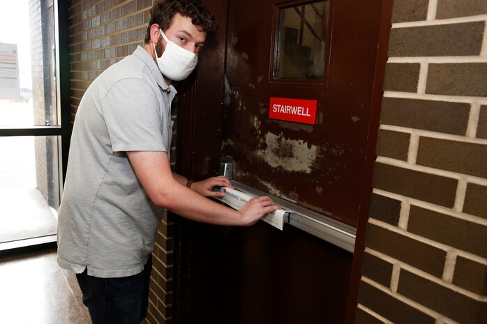 Nuclear Engineer (2310.2) Ben Campbell applies NanoSeptic technology to the stairwell door in Bldg. 1500 at Norfolk Naval Shipyard.