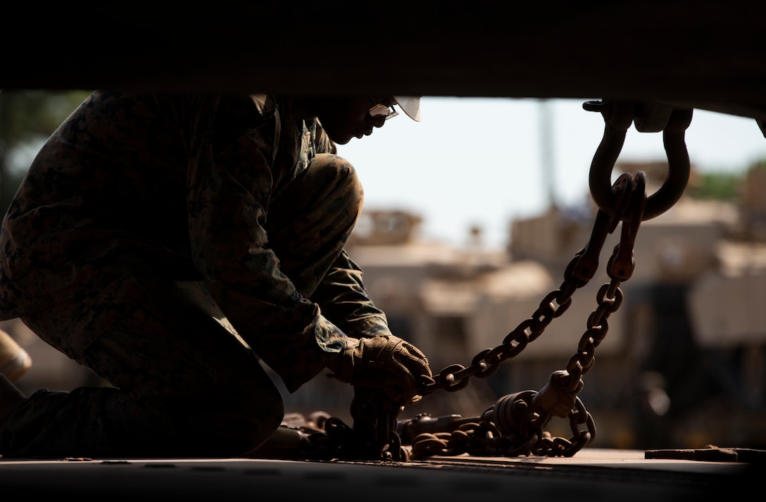 A U.S. Marine tightens a chain securing an M1A1 Abrams tank during the drawdown of Marine Corps armor divisions at Camp Lejeune, N.C., July 28.