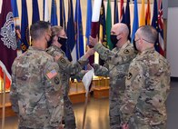 Master Sgt. Stacey Varga passes the U.S. Army Medical Materiel Agency colors to Col. Timothy Walsh during a Change of Command ceremony Aug. 7 at Fort Detrick, Maryland. Walsh relinquished command of USAMMA, a direct reporting unit to Army Medical Logistics Command, to Col. John “Ryan” Bailey. In the foreground are Bailey, left, and AMLC Commander Col. Michael Lalor. The ceremony also served as a Change of Responsibility for Varga and new USAMMA Sgt. Maj. Monnet Bushner.