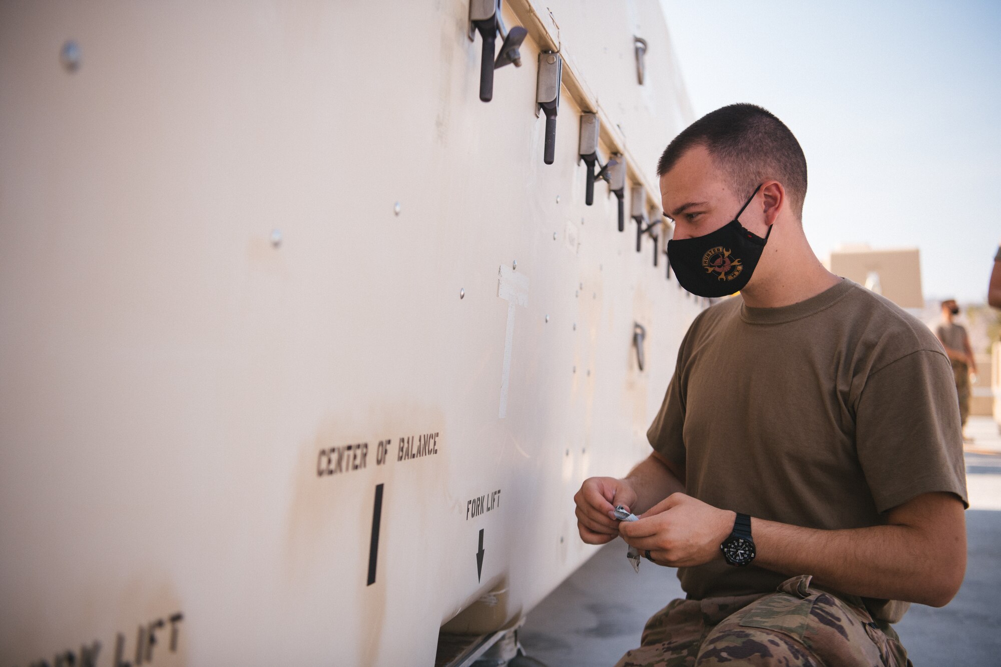 Tech. Sgt. Kyle, 432nd Aircraft Maintenance Squadron unit deployment manager stands next to an MQ-9 connex as he inspects it.
